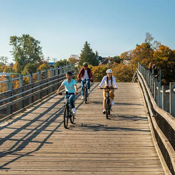 A group of friends cycle along the Selkirk Trestle in Victoria, BC