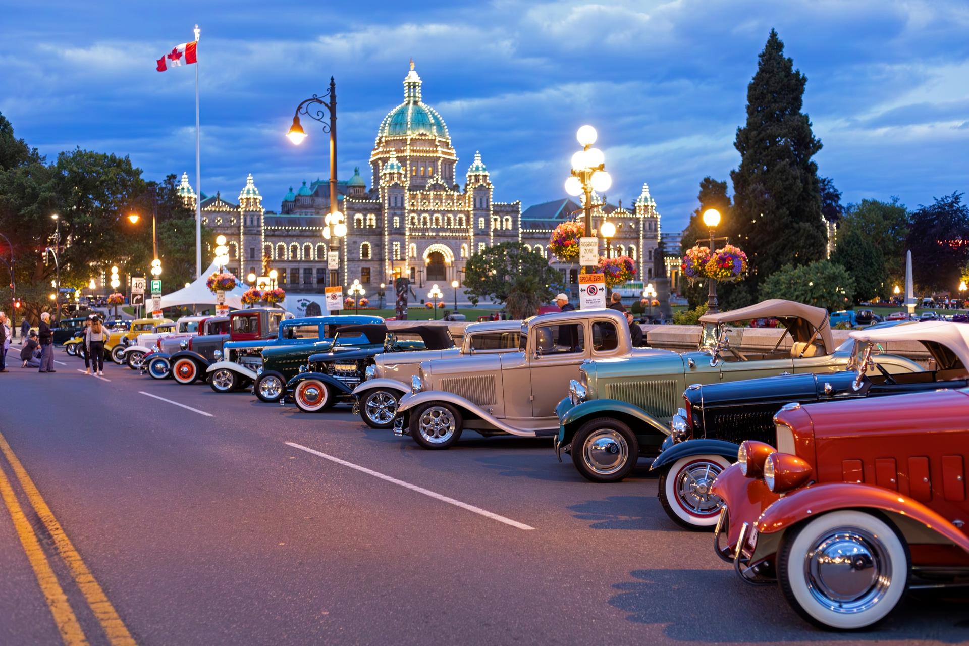 A lineup of Deuce Coupes in front of the glowing BC Legislature in Victoria, BC for Northwest Deuce Days.