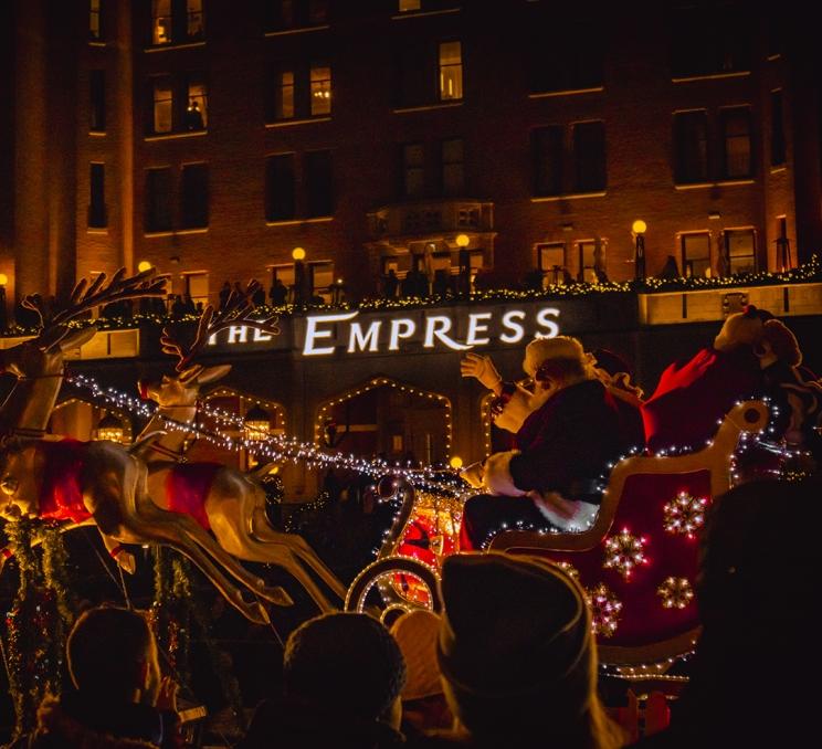Santa waves from his sleigh during the Santa Claus Parade in Victoria, BC as it passes the Fairmont Empress Hotel on the Inner Harbour