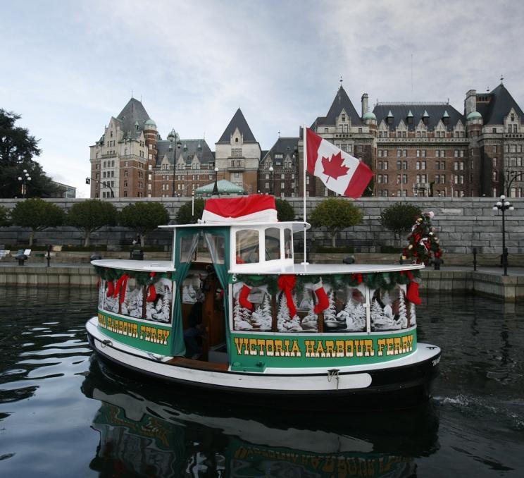 A Victoria Harbour Ferry decorated for the holidays cruises the Inner Harbour in Victoria, BC