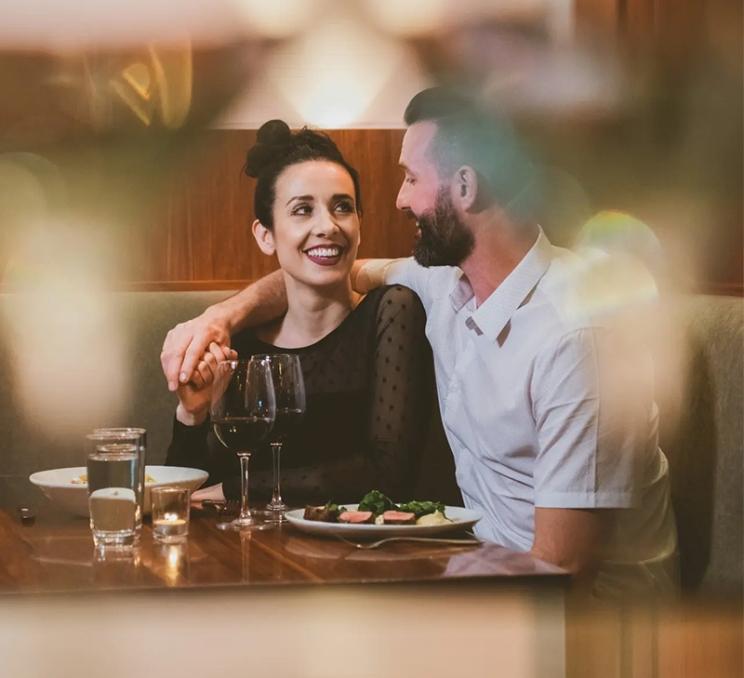 A couple enjoys a fine dinner and wine at The Palms Inspired Kitchen and Cocktails in Victoria, BC