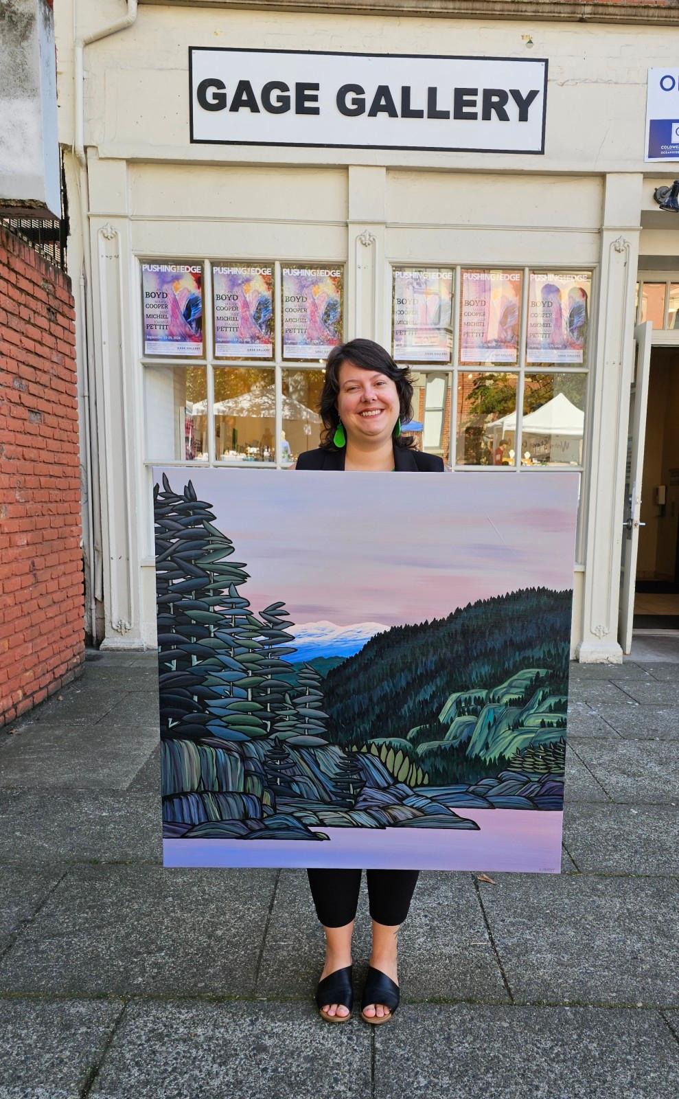 Kaillee in front of the gallery with her painting, Dusk Tides