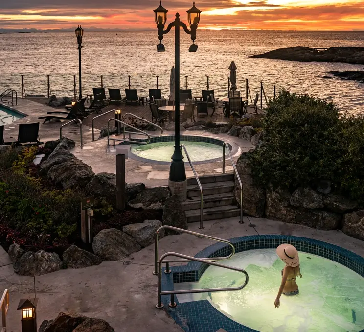 A woman takes a sunset soak in the mineral pools at the Oak Bay Beach Hotel in Victoria, BC