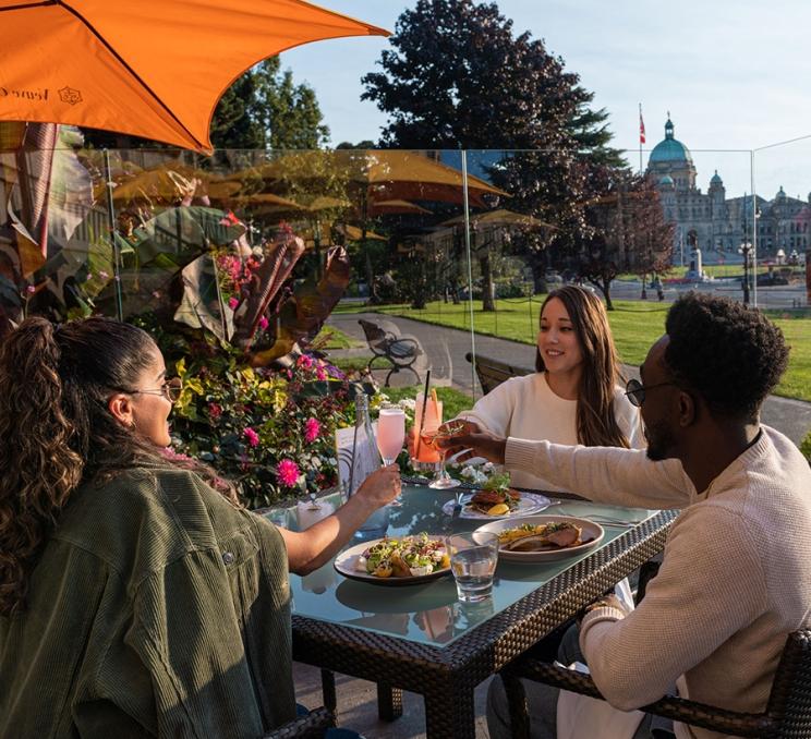A group of friends celebrate on the patio at Q at the Empress in Victoria, BC