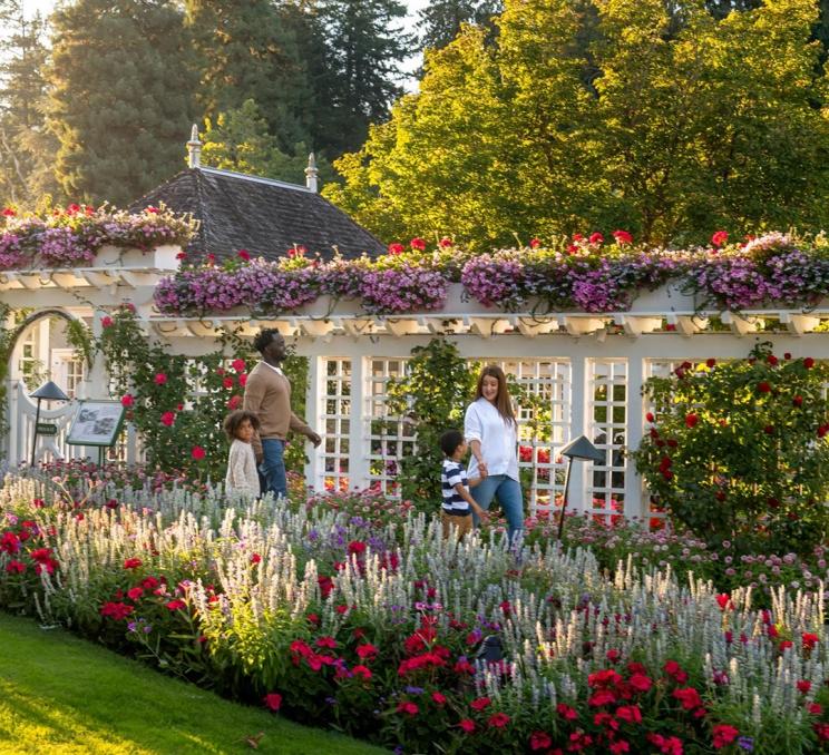A young family walks through The Butchart Gardens, a National Historic Site of Canada, in Victoria, BC