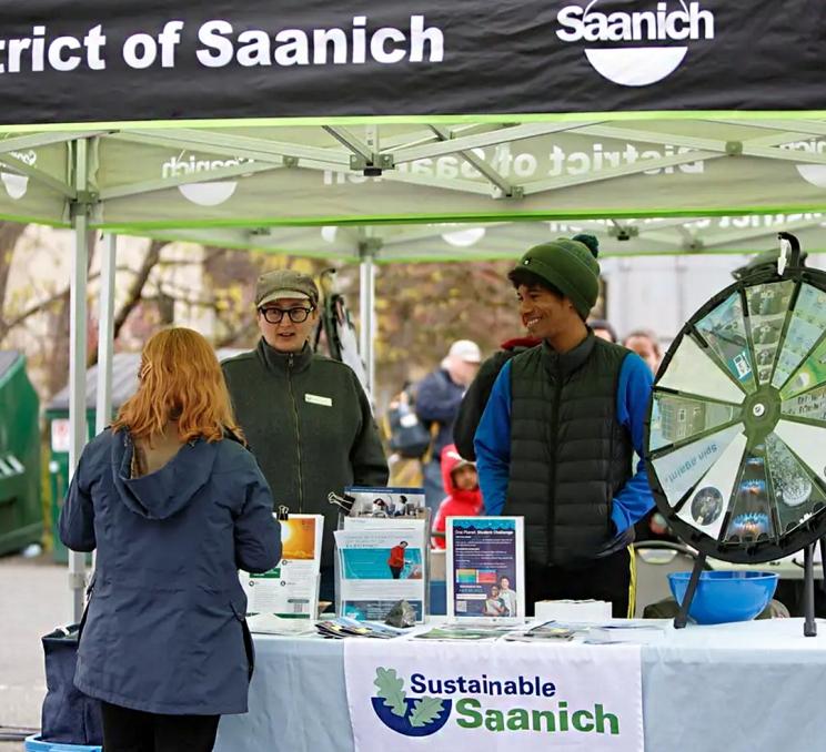 A visitor chats with event workers at the Saanich Earth Day Festival in Greater Victoria, BC