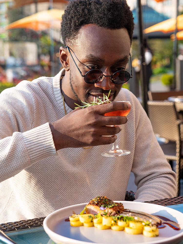 A man takes a sip from a cocktail while on the veranda at the Fairmont Empress in Victoria, BC