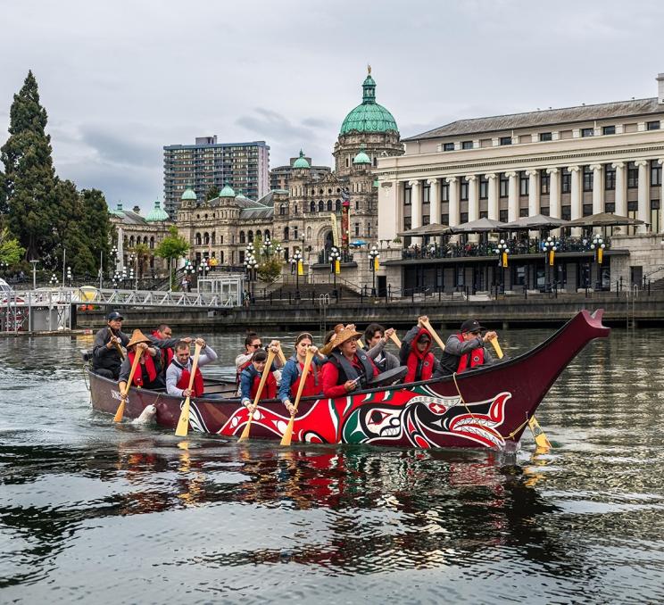 A Songhees Tours canoe tour explore the Inner Harbour in Victoria, BC