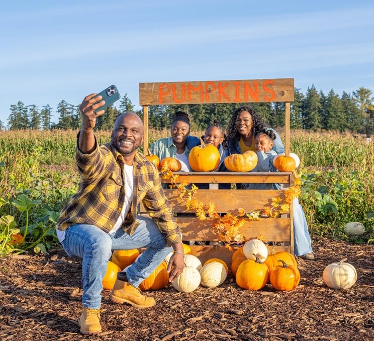 A young family poses for a selfie at the pumpkin patch at Ocean View Estates, a farm on the Saanich Peninsula in Victoria, BC