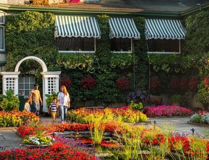 A young family walks through the Italian Garden at The Butchart Gardens in Victoria, BC