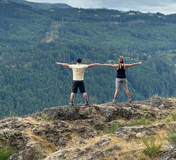 The guides from Vancouver Island Hikes, Bites + Beer pose for a photo atop a mountain in Victoria, BC