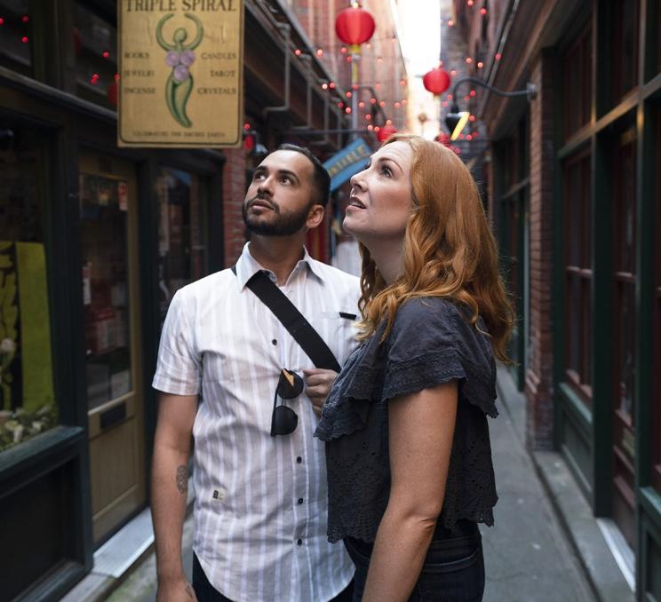 A couple examines the architecture inside Fan Tan Alley, Canada's narrowest street, in the historic Chinatown of Victoria, BC