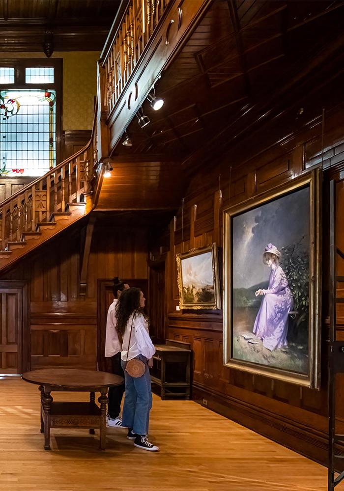 A young couple examine a painting in the Art Gallery of Greater Victoria in Victoria, BC