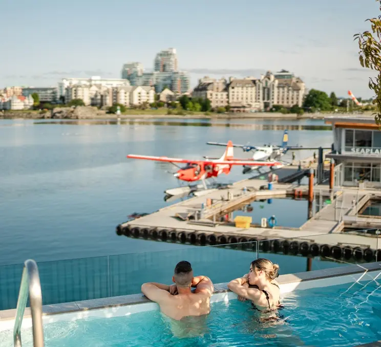A couple soaks in a hot tub overlooking Victoria, BC's Inner Harbour at HAVN Saunas