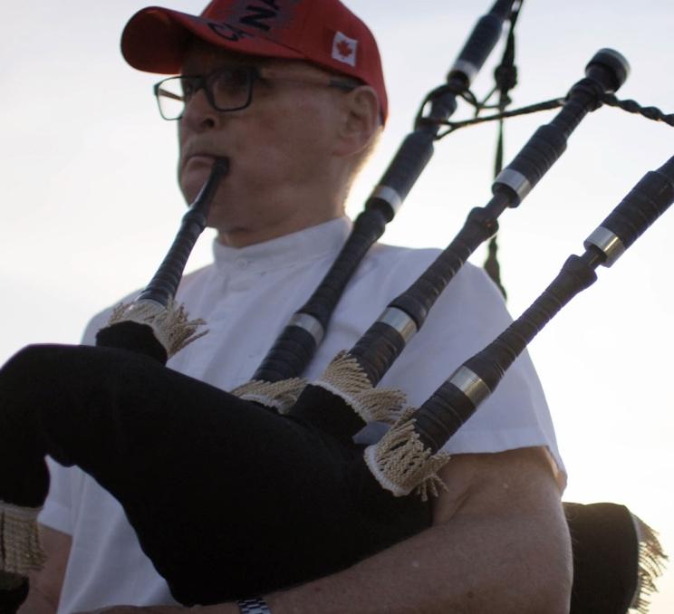 A bagpiper plays his bagpipes on Victoria, BC's Inner Harbour