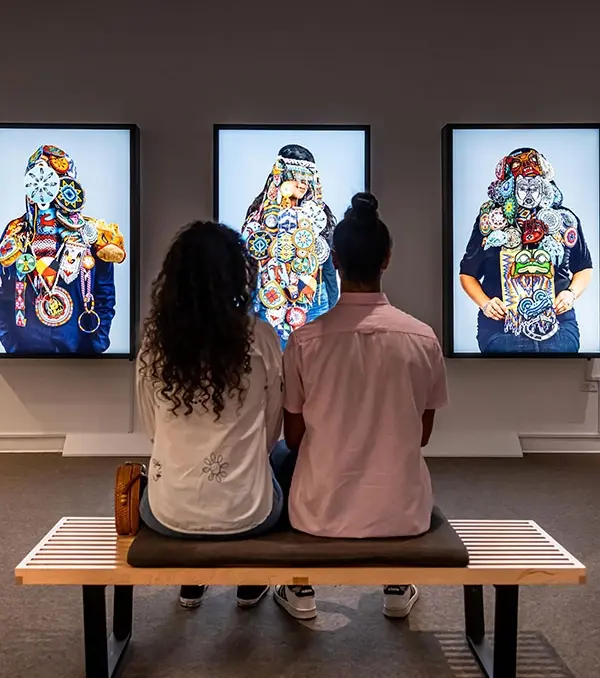 A couple visiting the Art Gallery of Greater Victoria sits down to view some art in Victoria, BC