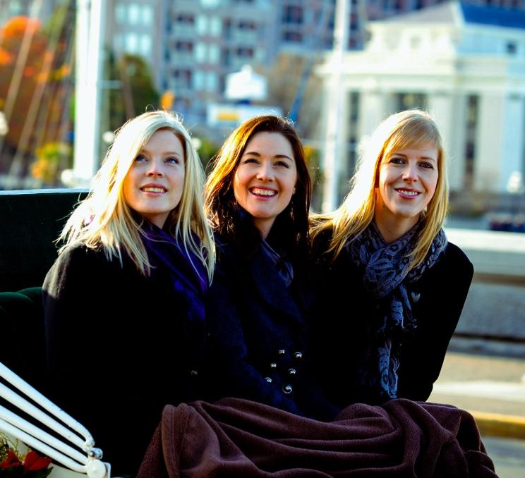 Three women enjoying a carriage tour of Victoria, BC's Inner Harbour in the wintertime