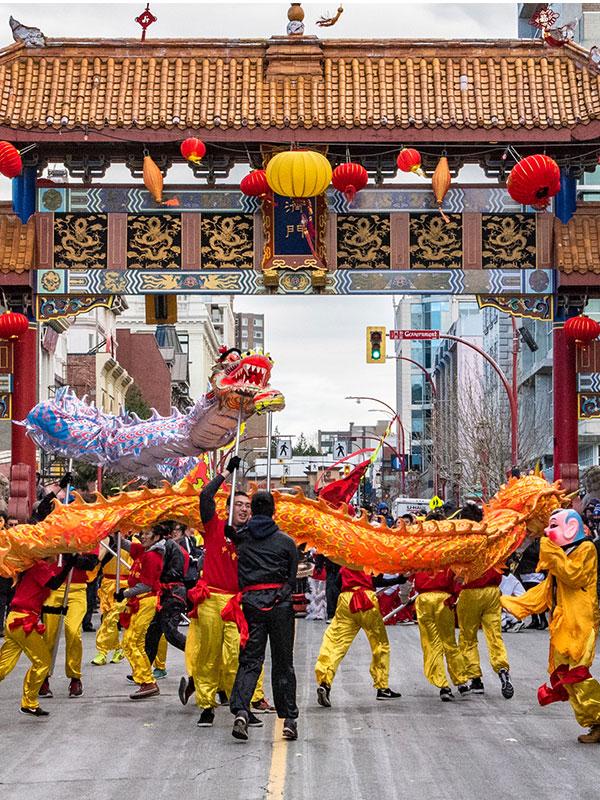 A Dragon Dance is performed during a festival in front of the Gate of Harmonious Interest in Victoria, BC's Chinatown
