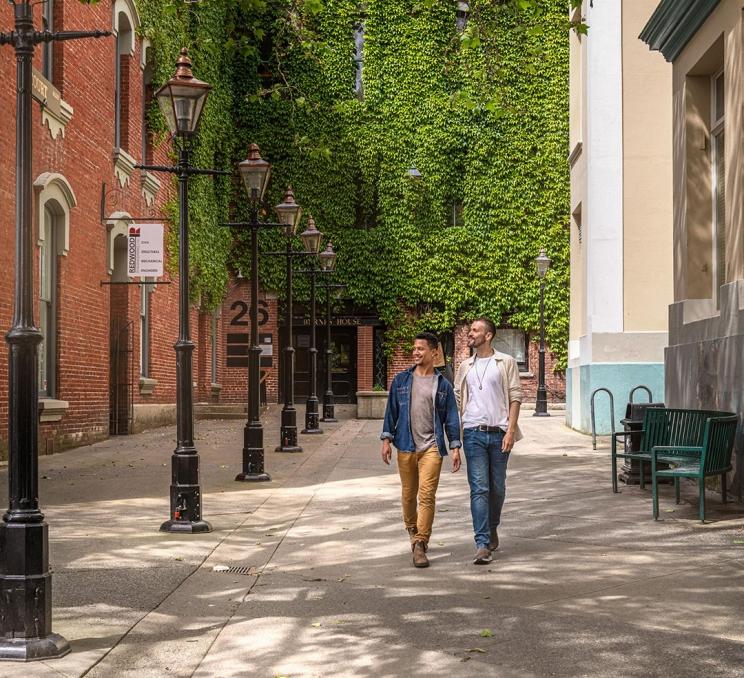 A male couple walks through Bastion Square in Victoria, BC
