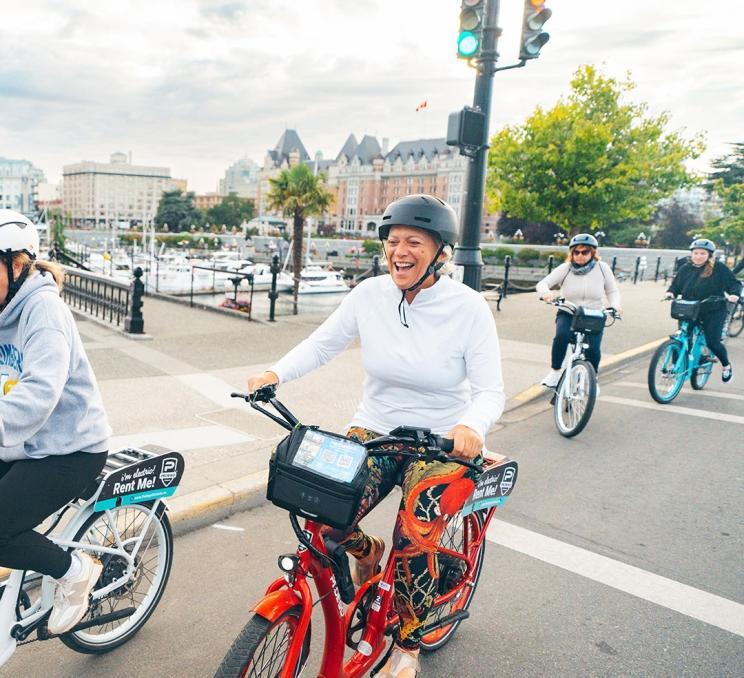 A cyclist rides an e-bike from Pedego around Victoria, BC's Inner Harbour