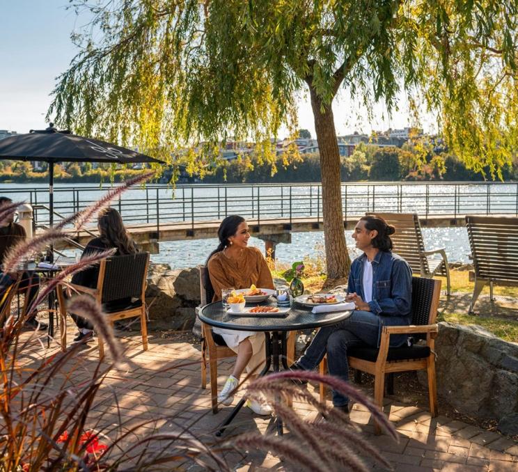 A couple dining on the patio at Glo Restaurant + Patio on Victoria BC's Inner Harbour