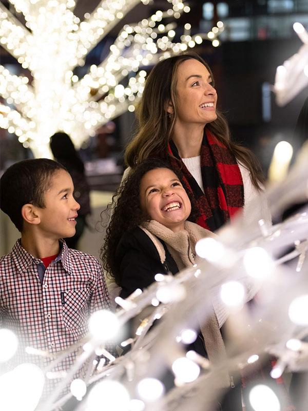 A mother and her two children enjoy the holiday lights at Lights of Wonder in Centennial Square in Victoria, BC