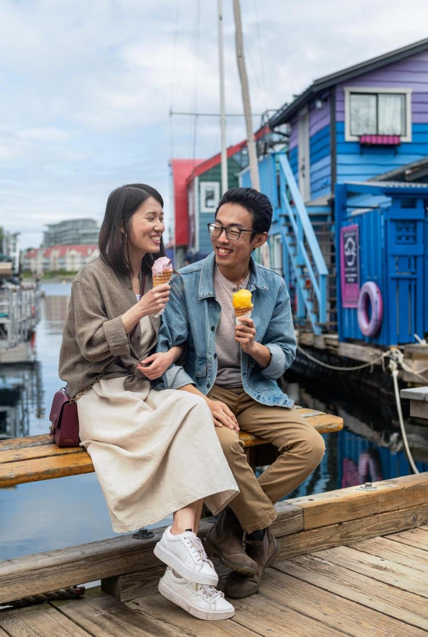 A young couple enjoys ice cream on the dock at Fisherman's Wharf in Victoria, BC