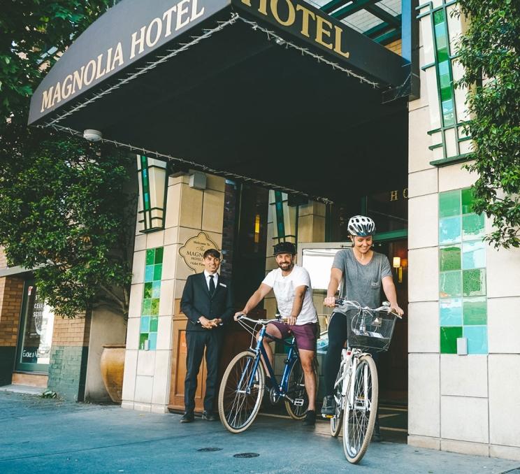 A couple leaves the Magnolia Hotel on Courtney Street by bike in Victoria, BC