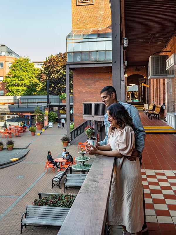 A couple looks down onto the plaza at Market Square in Victoria, BC