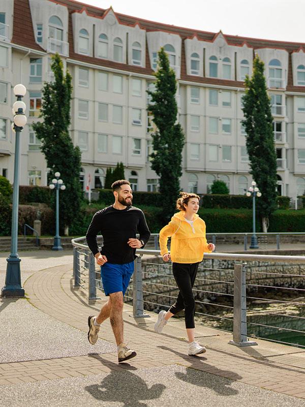 A couple goes for a run along the Songhees Walkway in the Vic West neighbourhood in Victoria, BC