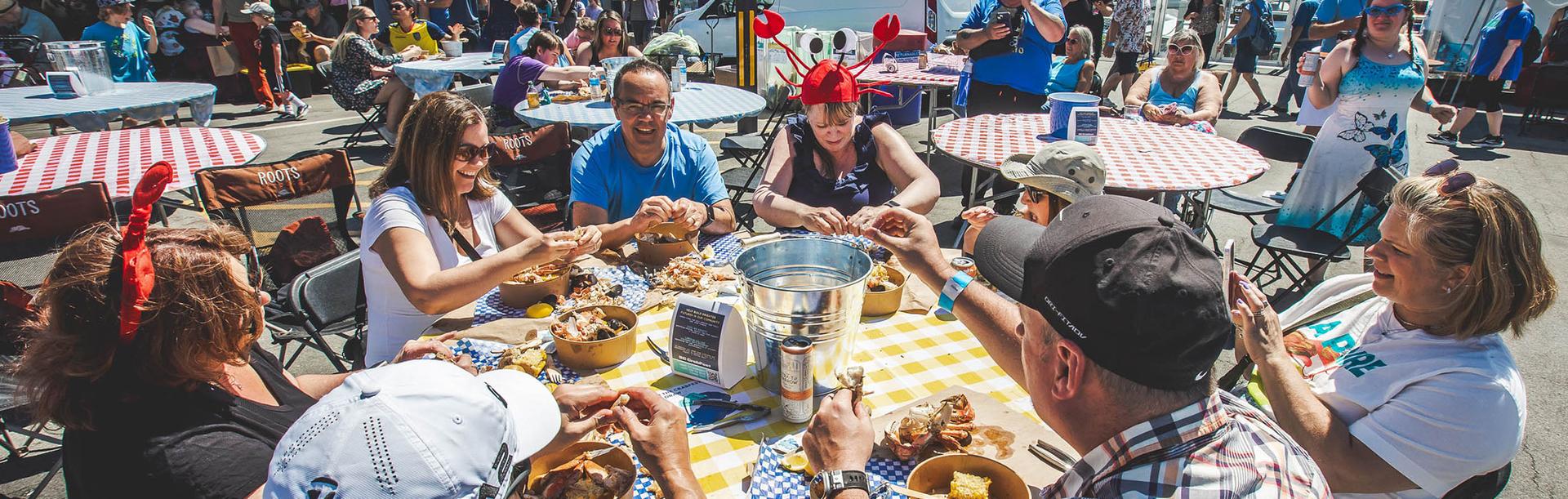 A group of people dine on crab legs at BC Crab Fest in Victoria, BC