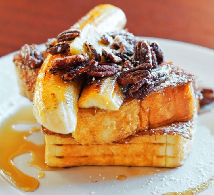 French toasts topped with pecans, banana and caramel drizzle in Victoria, BC