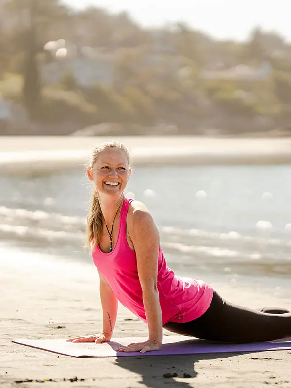 A woman practicing yoga on Gonzales Beach in Victoria, BC