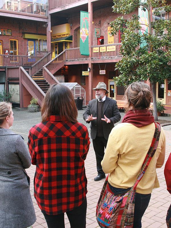 A guided walking tour from Discovery Walks Tours makes a stop at Market Square in Victoria, BC