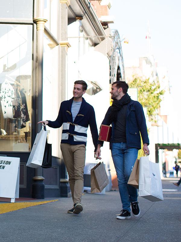 A male couple enjoys the shopping scene along Lower Johnson Street in Victoria, BC