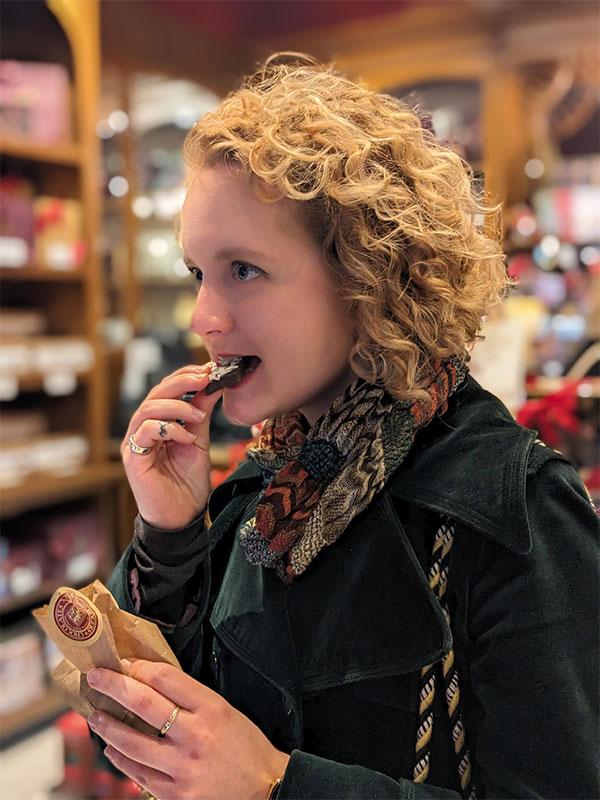 A woman bites into a sweet during an Off the Eaten Track food tour in Victoria, BC