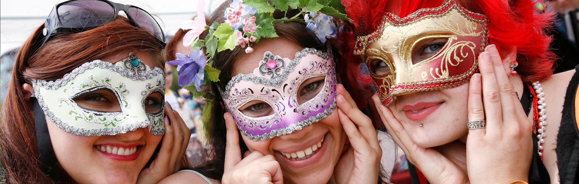 Three friends wearing masks pose for a photo at the Victoria Pride Parade in Victoria, BC