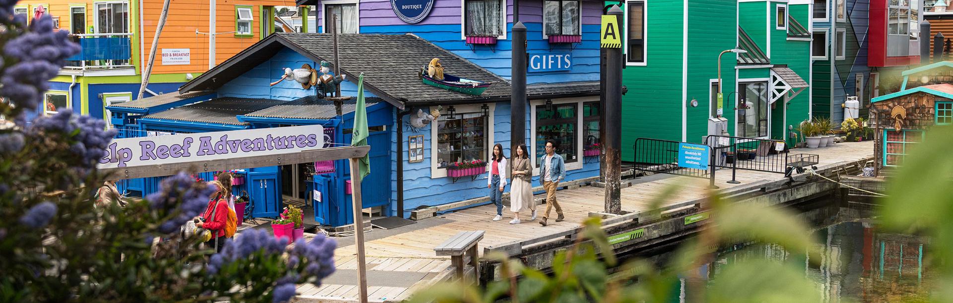 A family walks along the docks at Fisherman's Wharf in Victoria, BC
