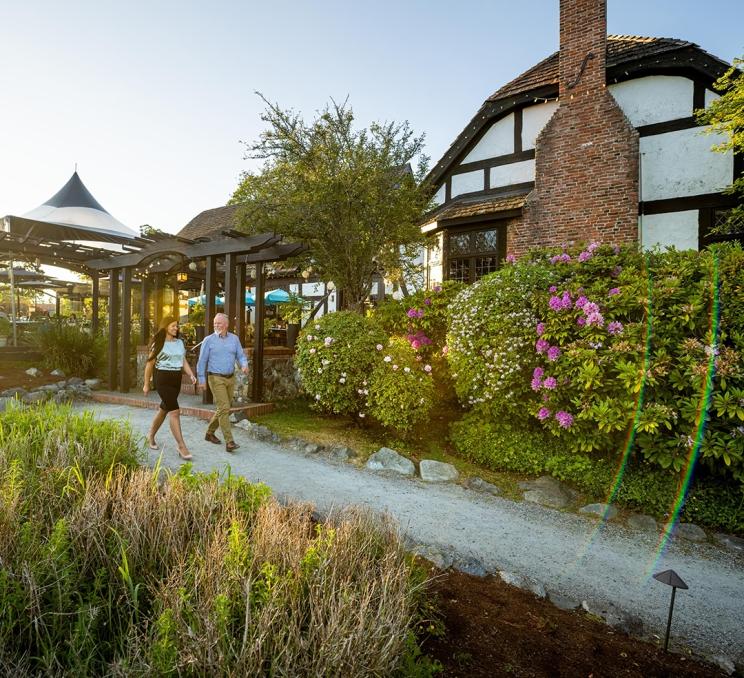 A couple walks along a pathway outside of Fireside Grill in Saanich, BC