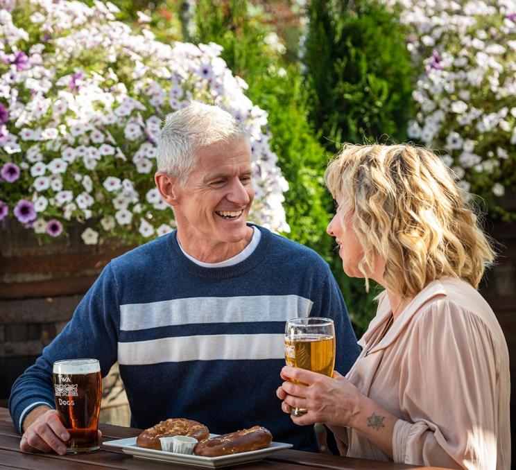 A couple shares beers and a pretzel at Macaloney's Island Distillery in Greater Victoria, BC