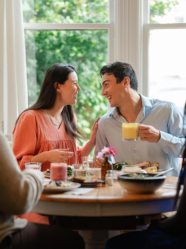 A couple having brunch with their friends at Nourish Kitchen + Cafe in Victoria, BC's James Bay neighbourhood