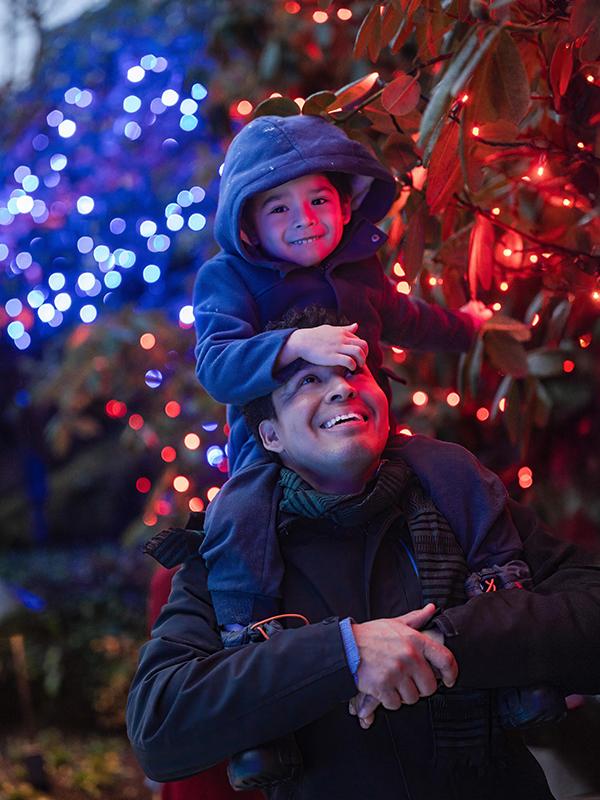 A father gives his son a piggyback ride through The Butchart Gardens during their Magic of Christmas holiday light display, in Victoria, BC