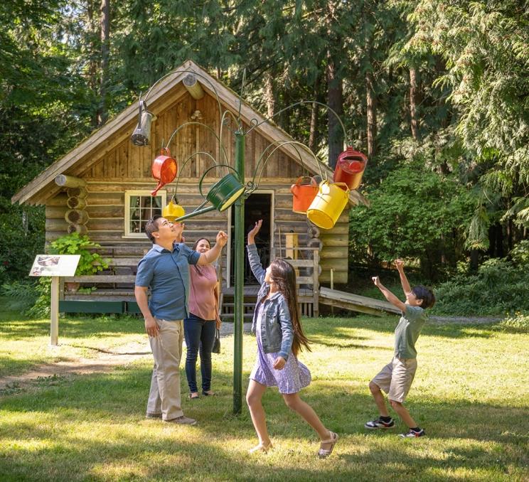 A family checks out a piece of public art at Heritage Acres in Victoria, BC