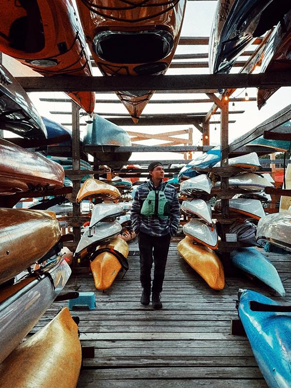 A person walks between a collection of kayaks on the dock at Pacifica Paddle Sports on the Saanich Peninsula