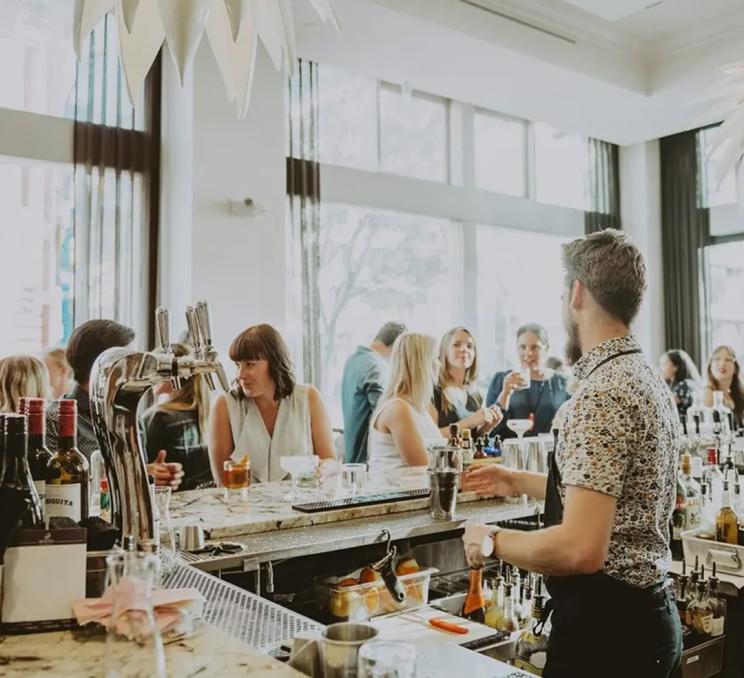 A bartender works the counter at The Palms Inspired Kitchen and Cocktails in Victoria, BC