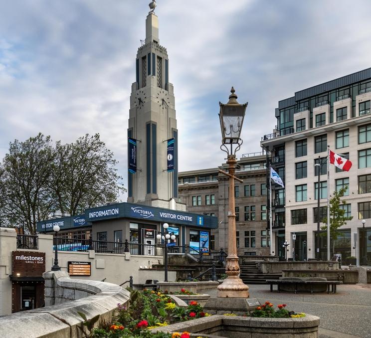 A view of the Victoria Visitor Centre at 812 Wharf Street in Victoria, BC from the nearby flower beds