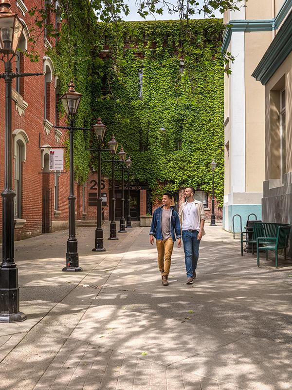 A male couple walks together through Bastion Square in Victoria, BC