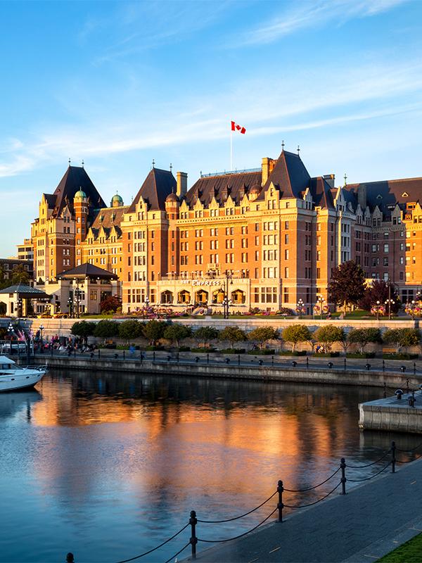 The Fairmont Empress illuminated at sunrise on Victoria, BC's Inner Harbour