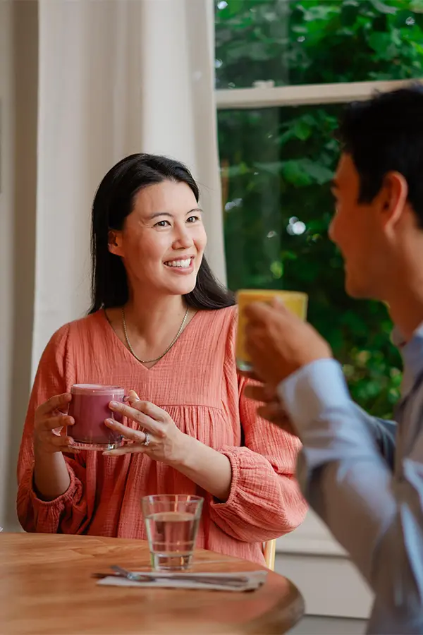 A woman and her partner enjoy lattes at Nourish Kitchen & Cafe, a farm-to-table restaurant set in a heritage house in Victoria, BC.