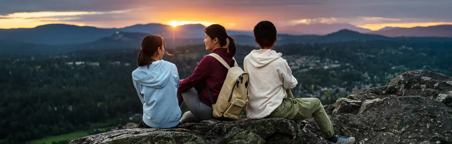 Family on PKOLs mountain watching the sunset in Victoria, BC